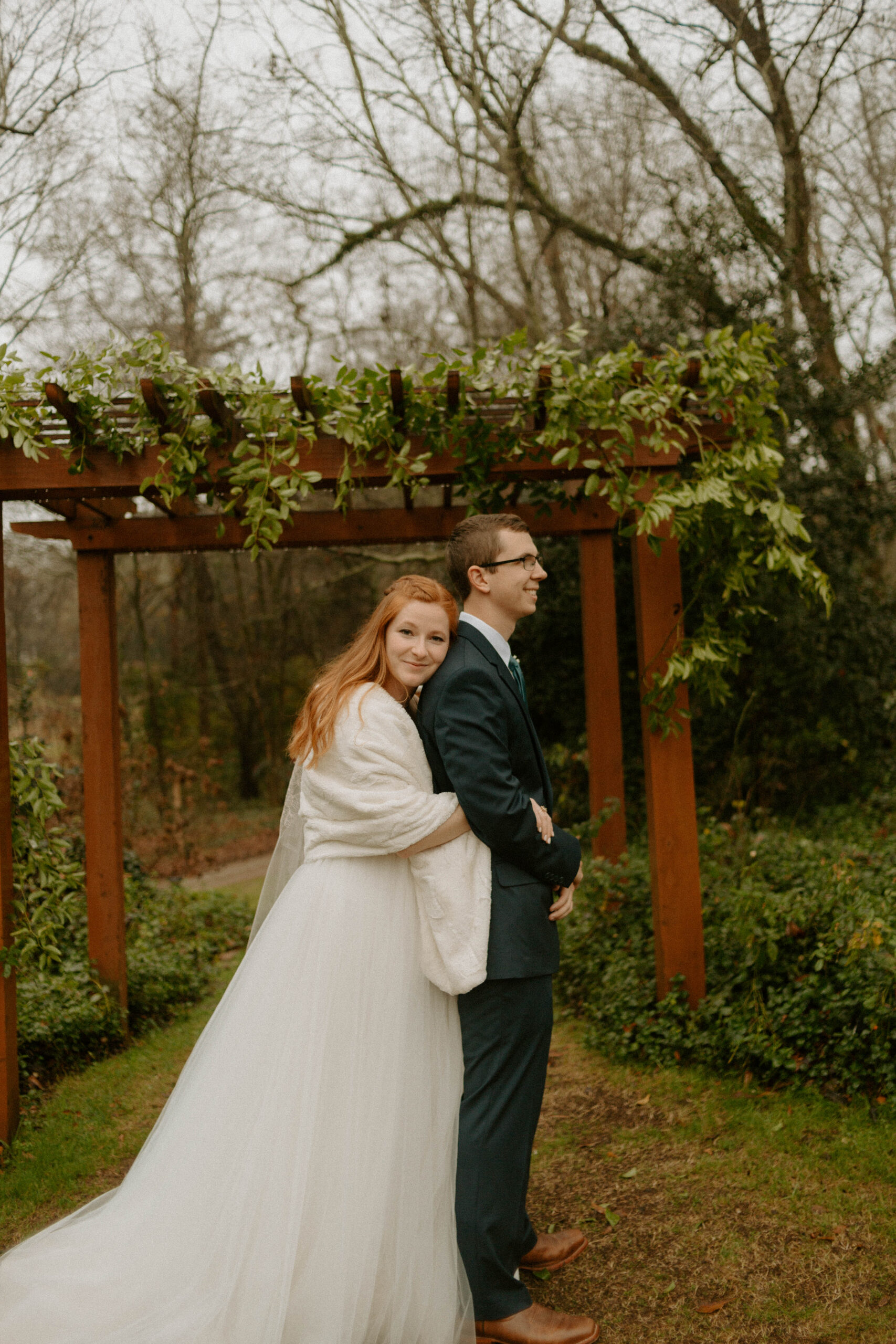Couple under pergola with greenery installation