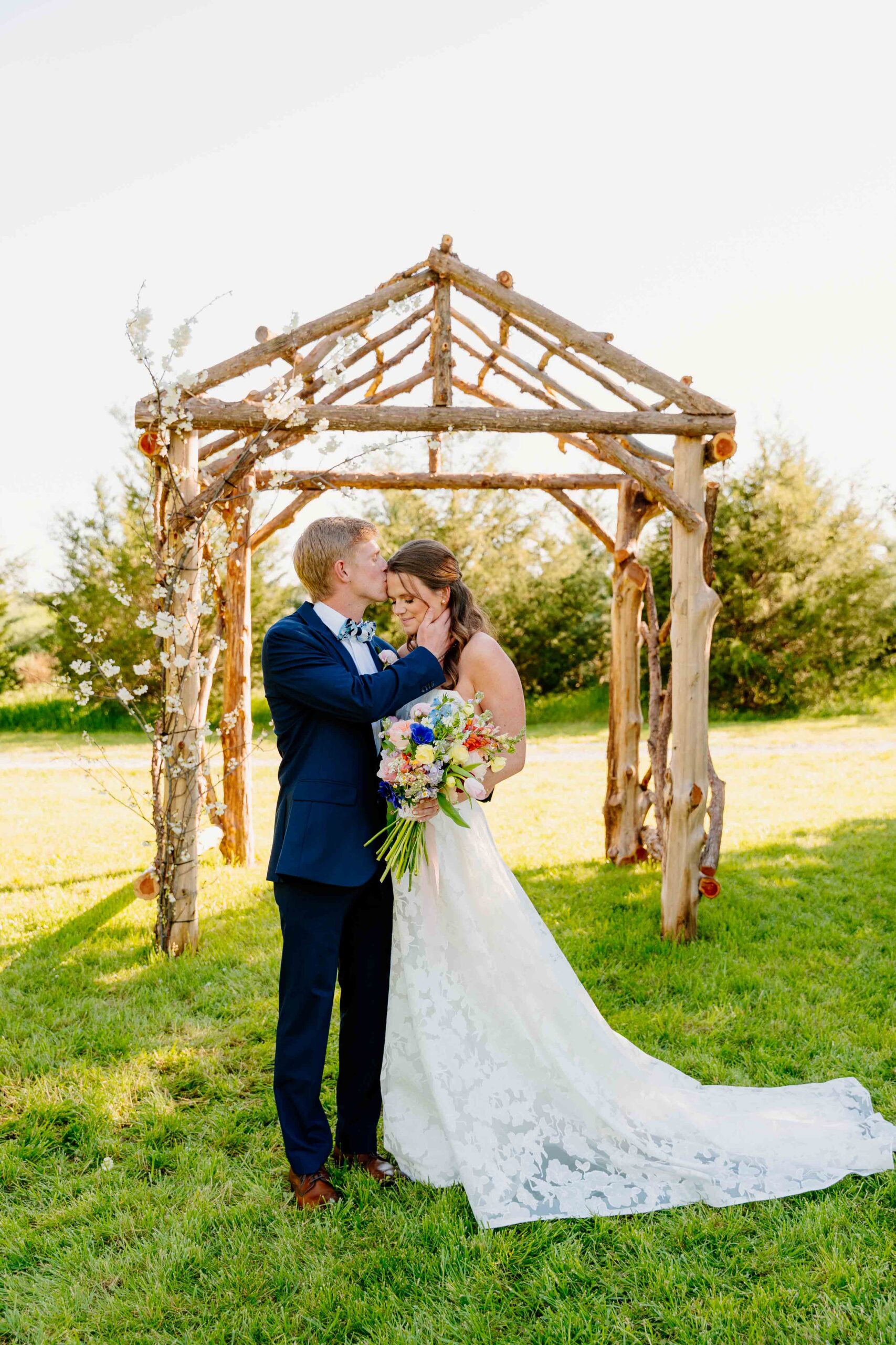 Couple at floral arbor ceremony installation